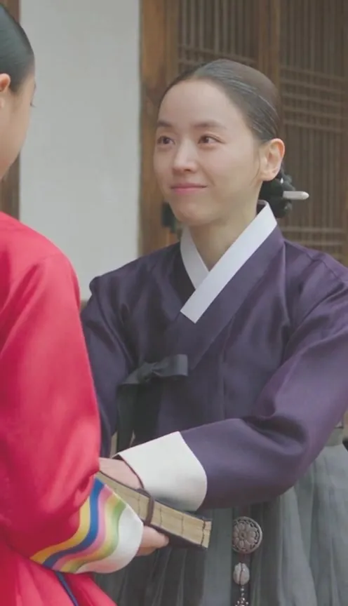 Now wealthy, she smiles at a visitor