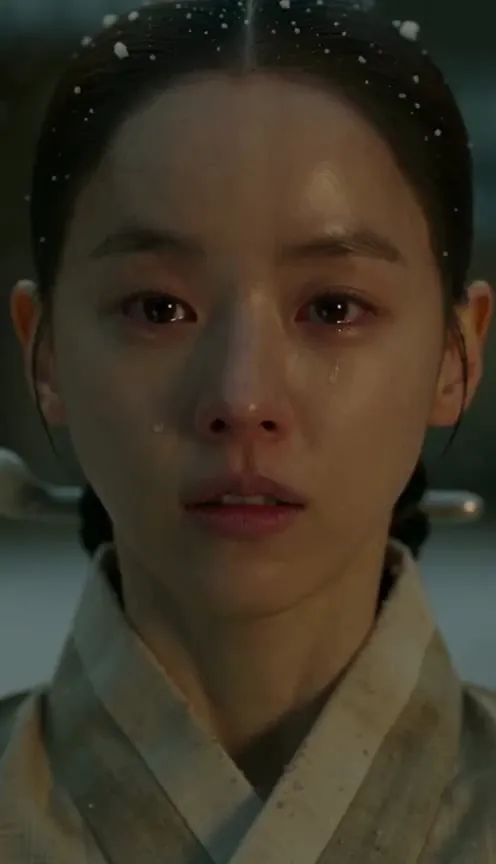 Snow falls on her face as she weeps